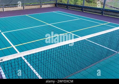 Elevated Platform Tennis, Paddle Ball courts with yellow pickelball lines and net.  Floor surface is green with white and yellow Stock Photo