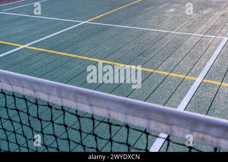 Elevated Platform Tennis, Paddle Ball courts with yellow pickelball lines and net.  Floor surface is green with white and yellow Stock Photo