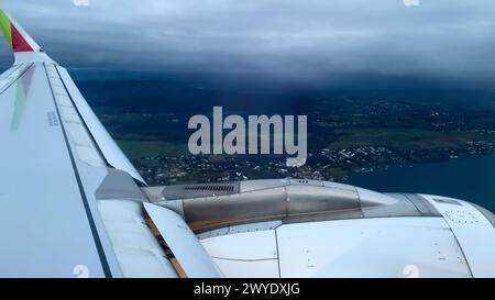 Rain showers pass over a landscape beside a lake as viewed from an airplane. Stock Photo