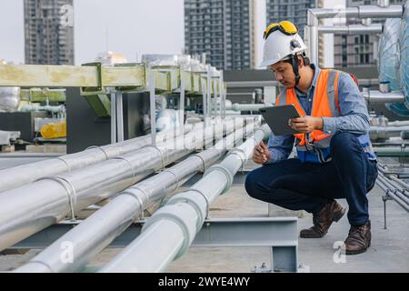 engineer male work checking water pipe inspecting valve testing water pump. Stock Photo