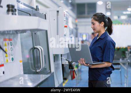 Asian women worker work in heavy industry with CNC lathe milling metal machine in steel product factory Stock Photo
