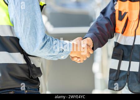 Engineer team dealing shaking hand together. Engineering cooperation group worker with construction manager teamwork working project successful. Stock Photo