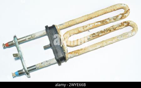 Old broken washing machine heater on white background Stock Photo