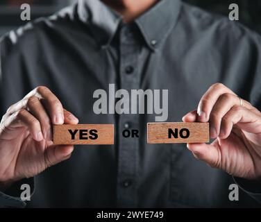 Businessman hands hold wooden blocks showing yes and no representing decision-making. Choice as a Stock Photo