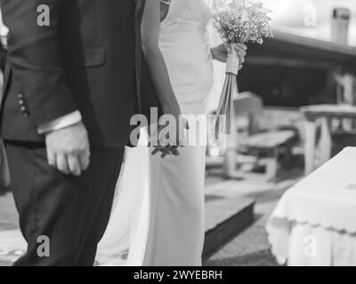 Groom and bride holding hands on their wedding day before first kiss, black and white photo Stock Photo