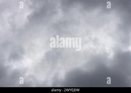 Full frame shot of dramatic sky and dark rain clouds. Gray, cloudy sky with hidden sun. Stock Photo