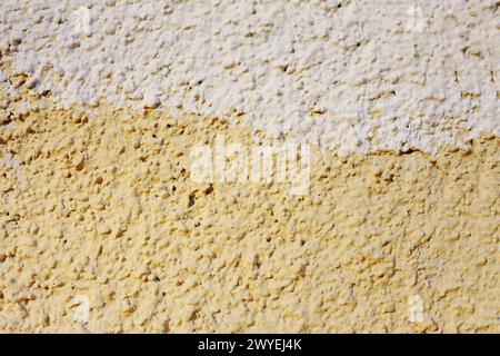 Abstract background of orange and beige paint on the wall close-up. The fong is half painted in different colors. Stock Photo
