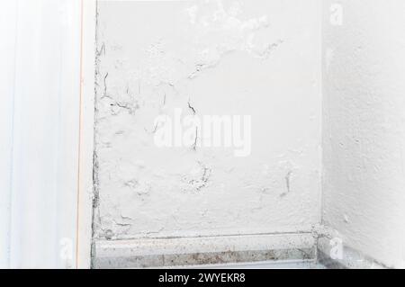 Peeling wall paint, moist damp texture on house wall with some water stain and leaks Stock Photo
