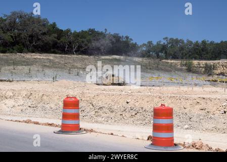 Excavation equipment leveling hills in Texas Hill Country to support urban sprawl, which many see as negative transformation to rural/ranch life. Stock Photo