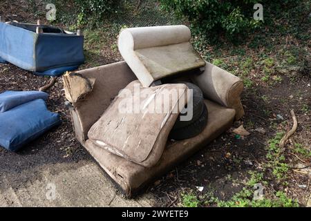 A Abandoned and Dumped Sofa Armchair at the Garages Flytipped in the Rain Stock Photo
