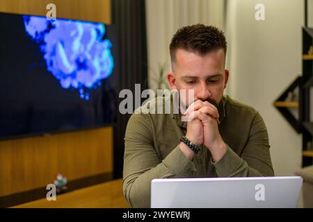 A young bearded Albanian  man working on his notebook from home. Stock Photo