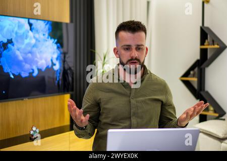A young bearded Albanian  man working on his notebook from home. Stock Photo
