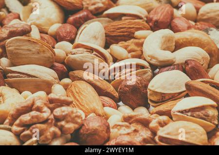 Variety of nuts and seeds closeup with selective focus - peeled walnut, hazelnuts, peeled peanut, pine nut kernels, almond seeds, cashew seeds, pistac Stock Photo