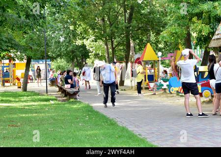People Are Resting In The City Park Walking Along Its Paths. Stock Photo