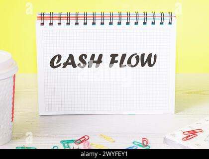 Cash flow text written on a piece of paper of a notebook standing on the table Stock Photo