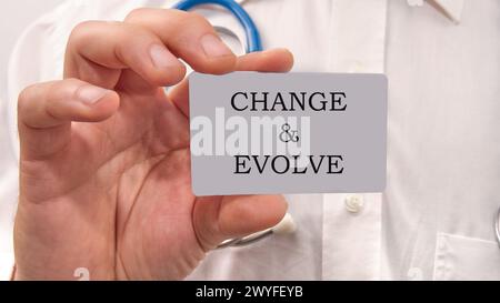 The text CHANGE EVOLVE written on a white card in the hands of a businessman Stock Photo