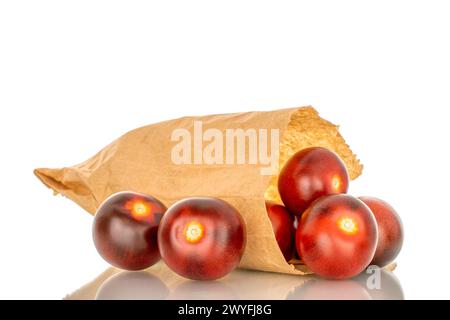 Several ripe black cherry tomatoes with paper bag, macro, isolated on white background. Stock Photo