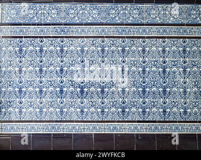 A pattern made of traditional blue floral Spanish tiles on a marble wall, background texture for text, graphic resource, Cadiz, Andalusia, Spain Stock Photo