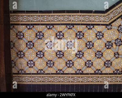 A pattern made of traditional colorful floral Spanish tiles on a marble wall, background texture for text, graphic resource, Cadiz, Andalusia, Spain Stock Photo