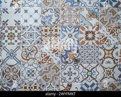A pattern made of traditional colorful floral Spanish tiles on a marble wall, background texture for text, graphic resource, Cadiz, Andalusia, Spain Stock Photo
