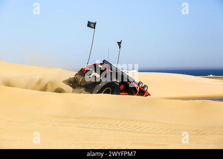 A view of dune buggies being driven by tourists at a desert safari park in the sand dunes near Inland Sea. Stock Photo