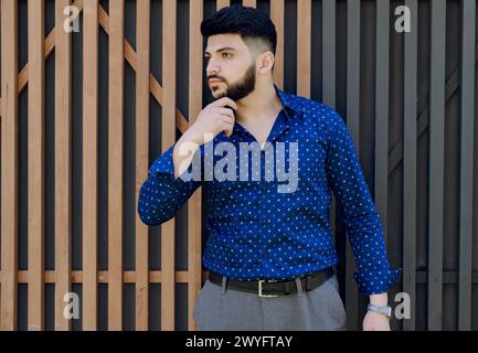 Handsome asian guy standing, touching chin. Stock Photo