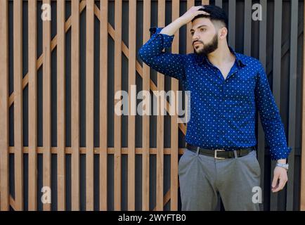 Brunette asian gay standing, touching hair. Stock Photo