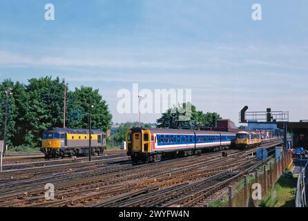 A Class 423 4 VEP EMU number 3463 pulls into Redhill with an up service while Class 73s numbers 73103 and 73114 pause in the centre roads and Class 33 number 33030 stands on the stabling point. 31st May 1994. Stock Photo