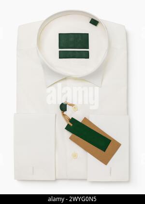 Folded dress shirt with stand collar, ivory color with long sleeves and cuffs for cufflinks, isolated on white background, top view, template for desi Stock Photo