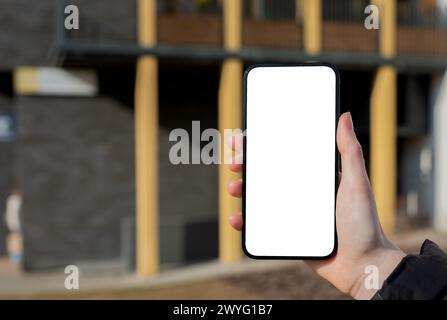 Hand holding mobile phone screen mockup, empty blank smartphone display, blurred city. Stock Photo