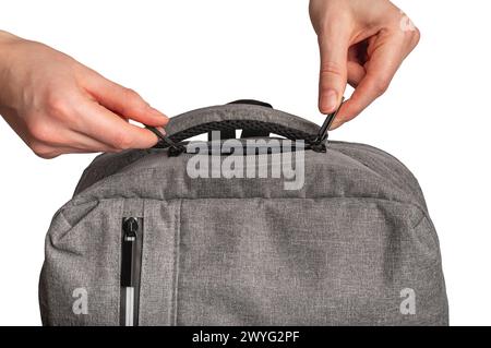Hands closing zip lock, zipper closure of textile bag, backpack isolated on white background. Stock Photo