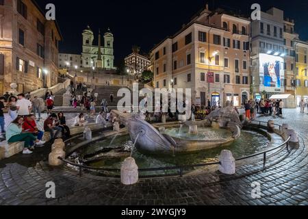 ROME, ITALY - MAY 24, 2022: A residential street in Rome, where people are dining outdoors at a small neighborhood restaurant on an old cobblestone st Stock Photo