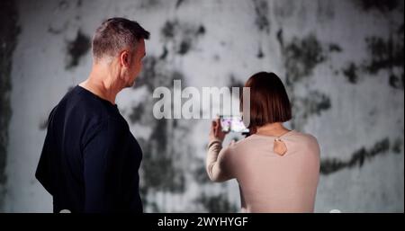 Taking Photo Of Home Wall Mold Damage Using Tablet Stock Photo