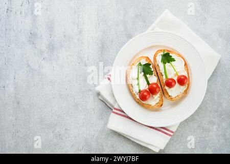 Funny toast in shape of ripe cherries sandwich with cream cheese, bread, cherry tomato, onion and parsley. Food art idea for kids food. Creative break Stock Photo