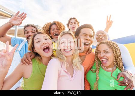 Happy blonde woman taking selfie with multiethnic friends Stock Photo