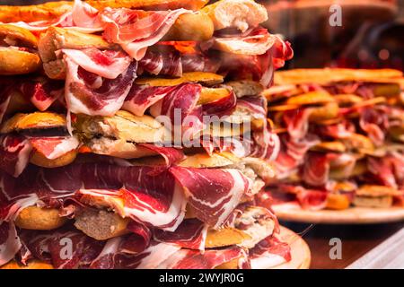 Traditional Spanish bocadillos with Iberico jamon laid out in a slide on a shop window Stock Photo