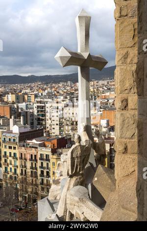 Spain, Catalonia, Barcelona, Eixample district, Sagrada Familia basilica by Catalan modernist architect Antoni Gaudi, listed as a UNESCO World Heritage Site, the Cross at the top of the passion facade whose sculptures were made by Josep Maria Subirachs Stock Photo