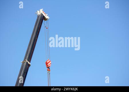 Road crane with a hook in it on a blue sky background Stock Photo