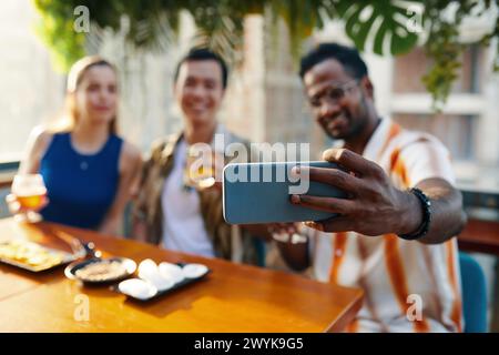 Man filming himself spending time with friends in bar Stock Photo