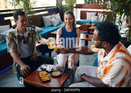 Cheerful friends having drinks in bar after work Stock Photo