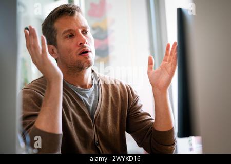 Portrait of a disappointed man programmer looking stressed out while working on a computer code Stock Photo
