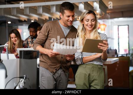 Close up diverse colleagues using tablet together, discussing online project Stock Photo