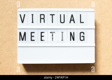 Lightbox with word virtual meeting on wood background Stock Photo