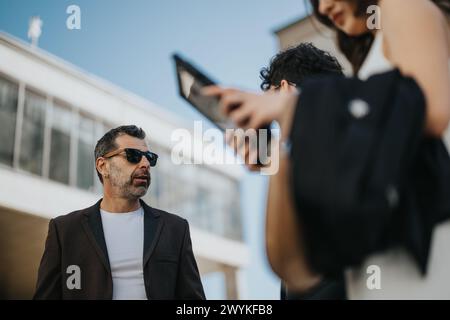 Business team reviewing data on tablet during outdoor meeting in city Stock Photo