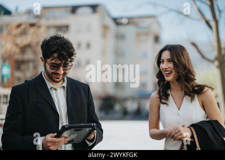 Business colleagues discussing data on tablet during a meeting outside in the city Stock Photo