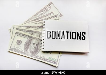 Card with the word Donations and dollars on a white background. Stock Photo