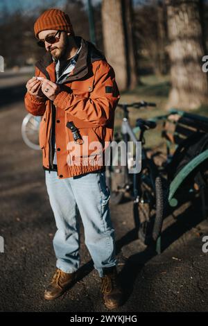 Fashionable hipster man chilling in a park with his bicycle on a sunny day Stock Photo
