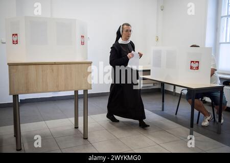 A nun holds her ballot card at the polling station during the local elections. Voters across Poland are casting ballots in local elections in the first electoral test for the coalition government of PM Donald Tusk nearly four months since it took power. Voters elected mayors as well as members of municipal councils and provincial assemblies. Among those running is Rafal Trzaskowski - Mayor of Warsaw, a Tusk ally who is seeking a second term. Opinion polls showed the two largest political formations running neck-and-neck: Tusk's Civic Coalition, an electoral coalition led by his centrist and p Stock Photo