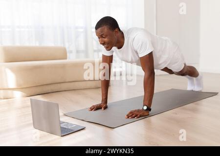 Man in a push-up position in a clean room Stock Photo