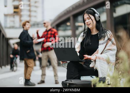 Entrepreneurs and partners engaged in a business meeting outdoors with one using a laptop Stock Photo